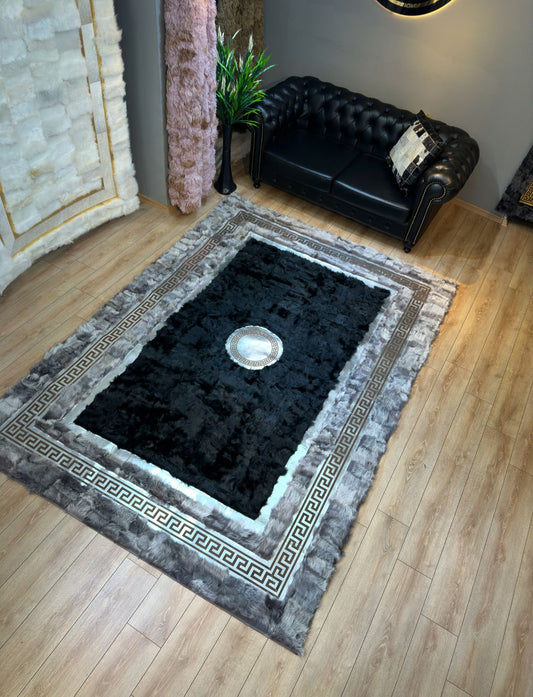 Handmade sheepskin gray black area rug with plush texture and decorative border in modern living room setting