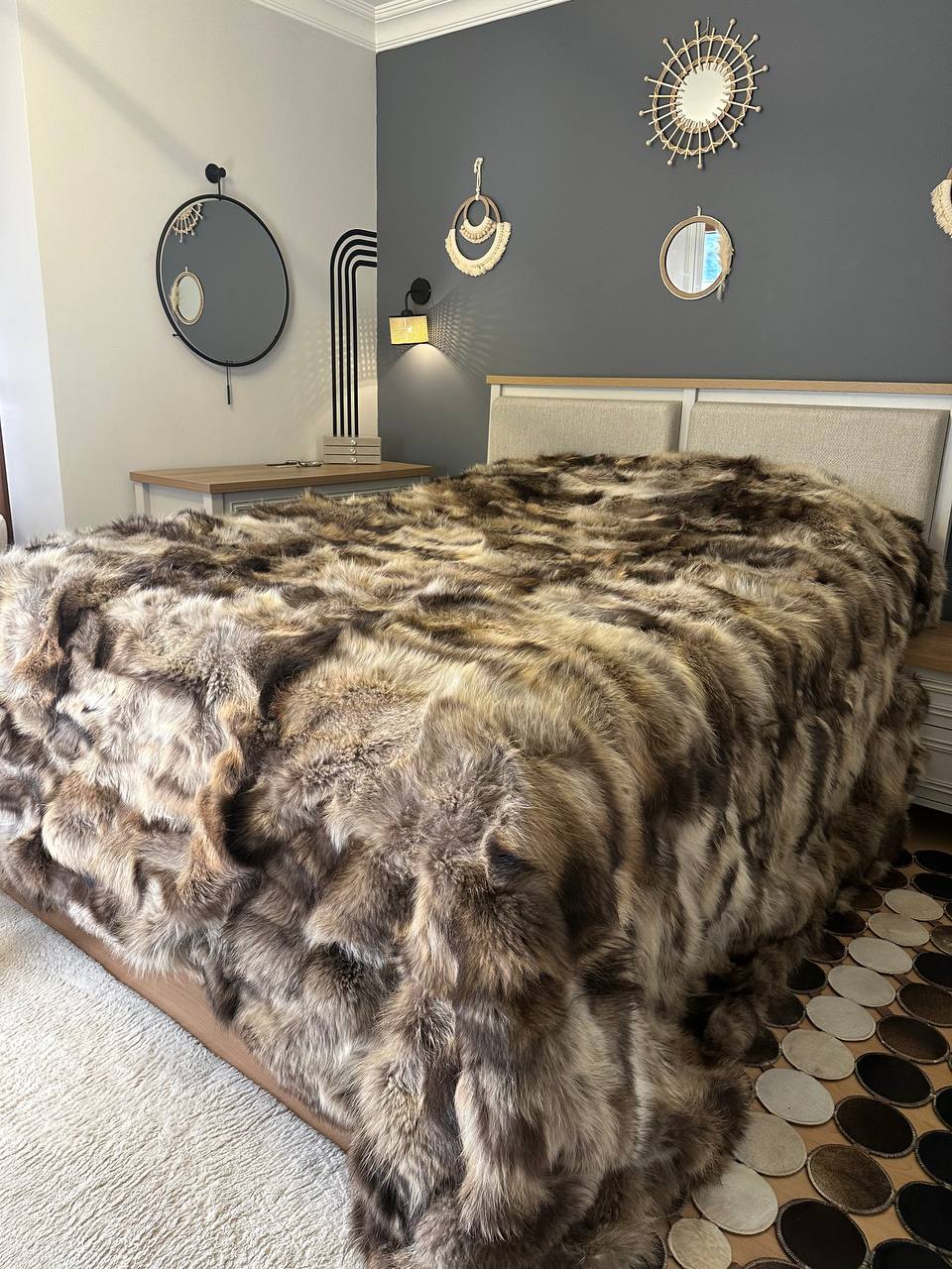 Handmade natural raccoon fur bedspread on bed in modern bedroom interior