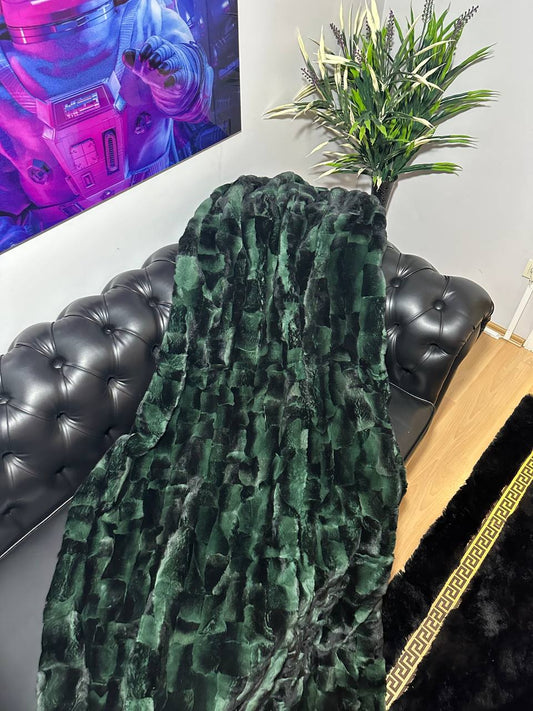 Luxury real green rabbit fur blanket draped over black leather sofa in modern living room