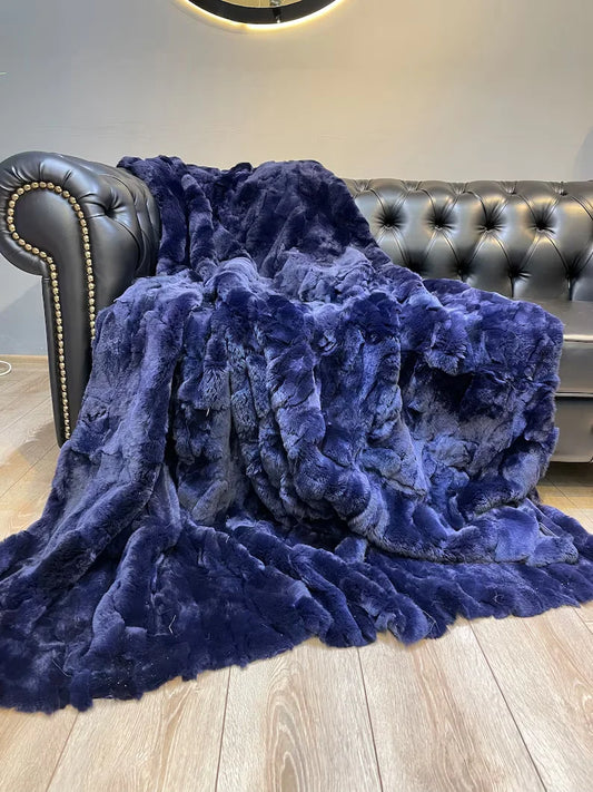 Unique handmade blue natural rabbit fur blanket draped over gray leather sofa