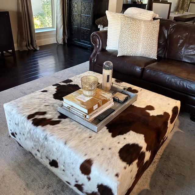 genuine cowhide coffee table ottoman with brown and white spots in living room setting
