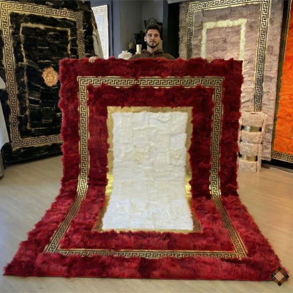 A genuine handmade sheepskin area rug with rich red tones and gold Greek key detail. Soft, luxurious, and custom-made for elegant interiors.