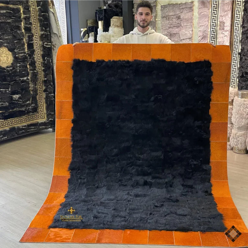 Black sheepskin rug with warm orange cowhide border, soft and luxurious handcrafted design