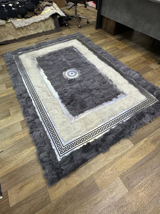 Handmade black beige sheepskin rug with geometric border on wooden floor in living room